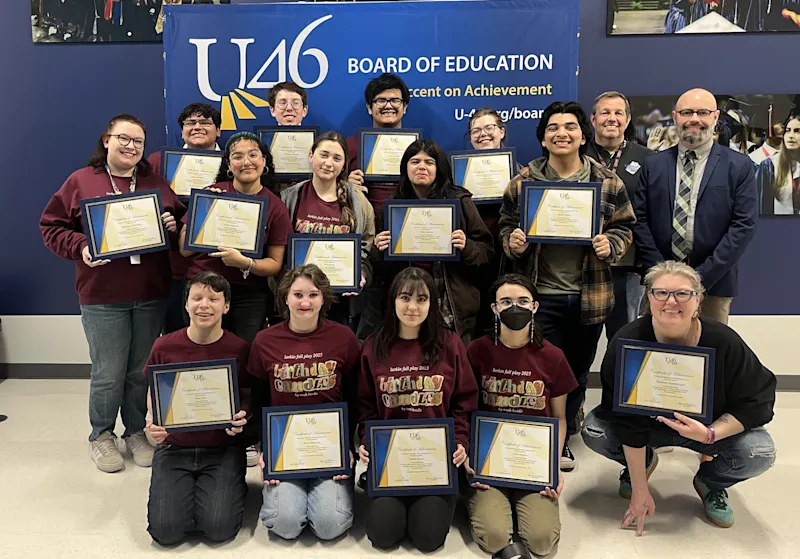 A group of high schoolers pose in front of a U-46 backdrop holding Accent on Achievement certificates