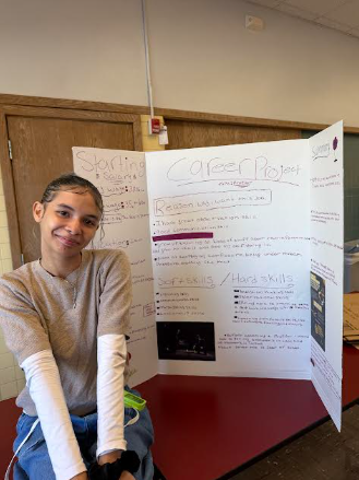 A smiling student stands next to a trifold science fair project board titled Career Project.