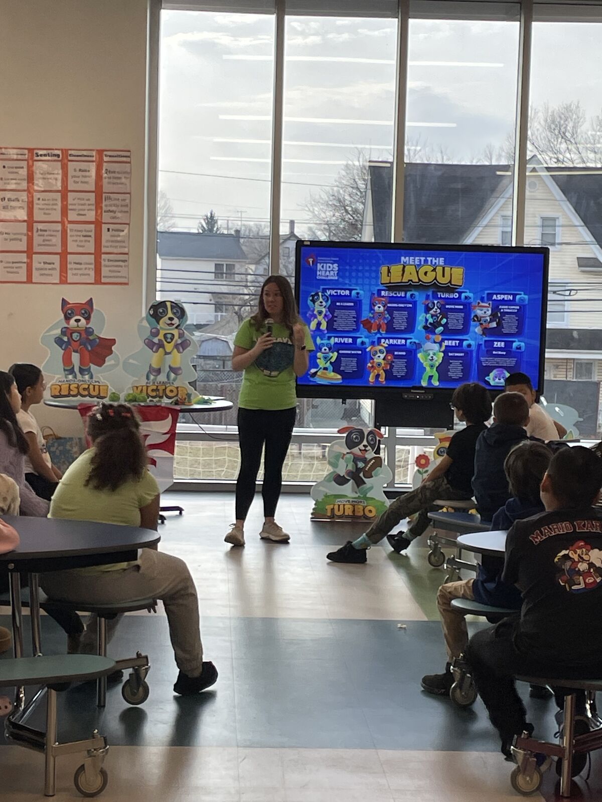 Students sit at lunch tables and listen to a presentation about the Kids Heart Challenge in the newly renovated cafeteria.