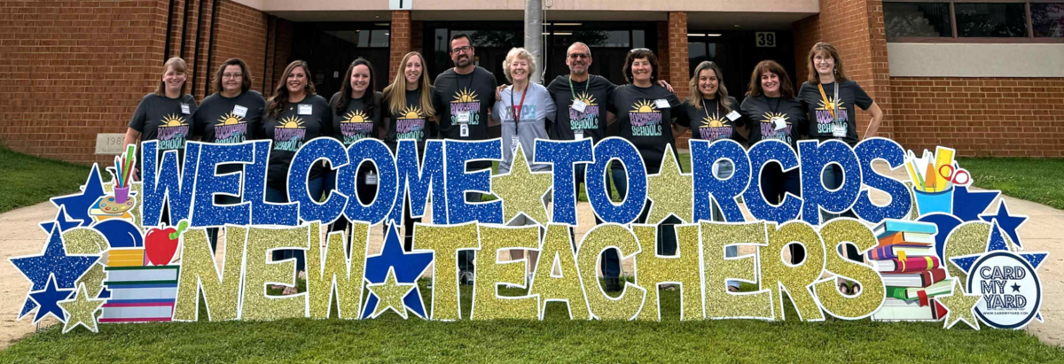 A group of teachers stand behind a large yard sign that reads 'WELCOME TO RCPS NEW TEACHERS'.