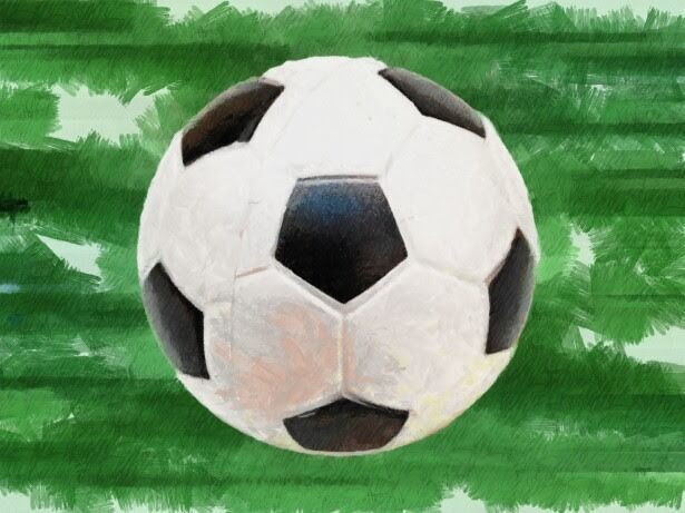 A close-up of a classic black and white soccer ball on a green, textured background.