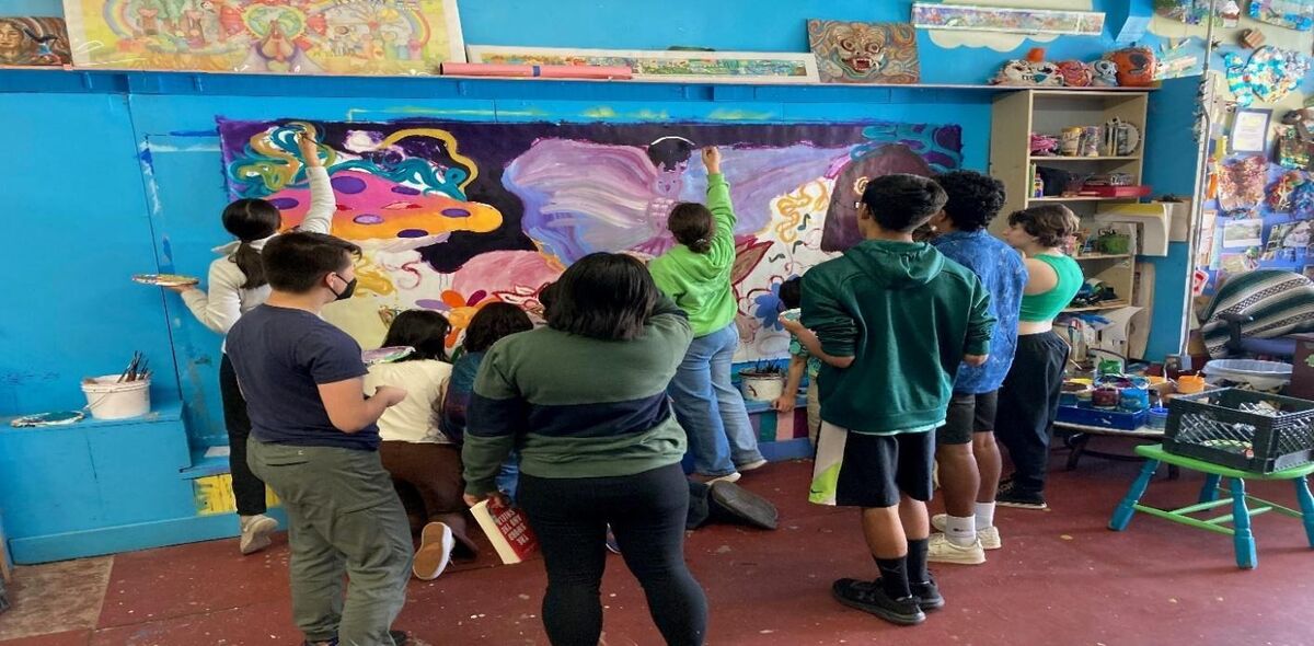 A group of people painting on a wallDescription automatically generated