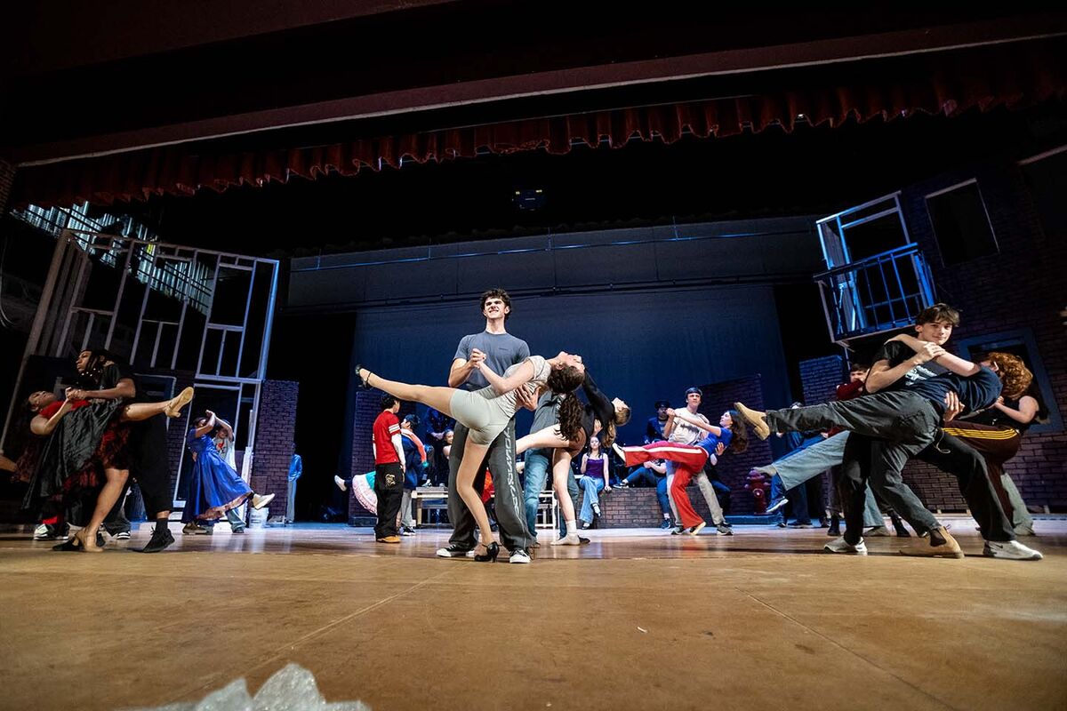A group of young people rehearse dance moves