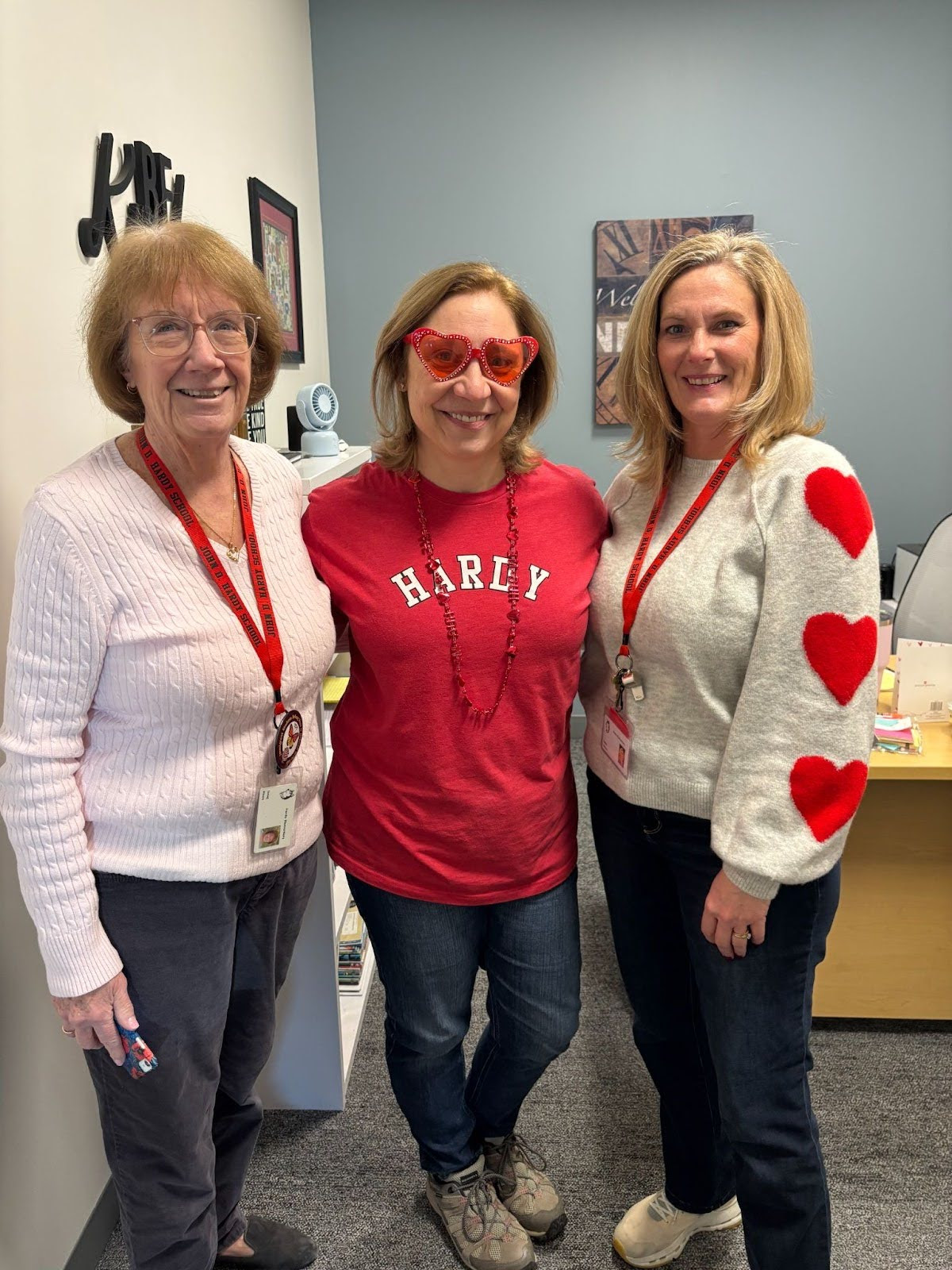 Ms. Rixon, Nurse Warmington, and Ms. O'Brien pose in Valentine's Day themed clothing. 