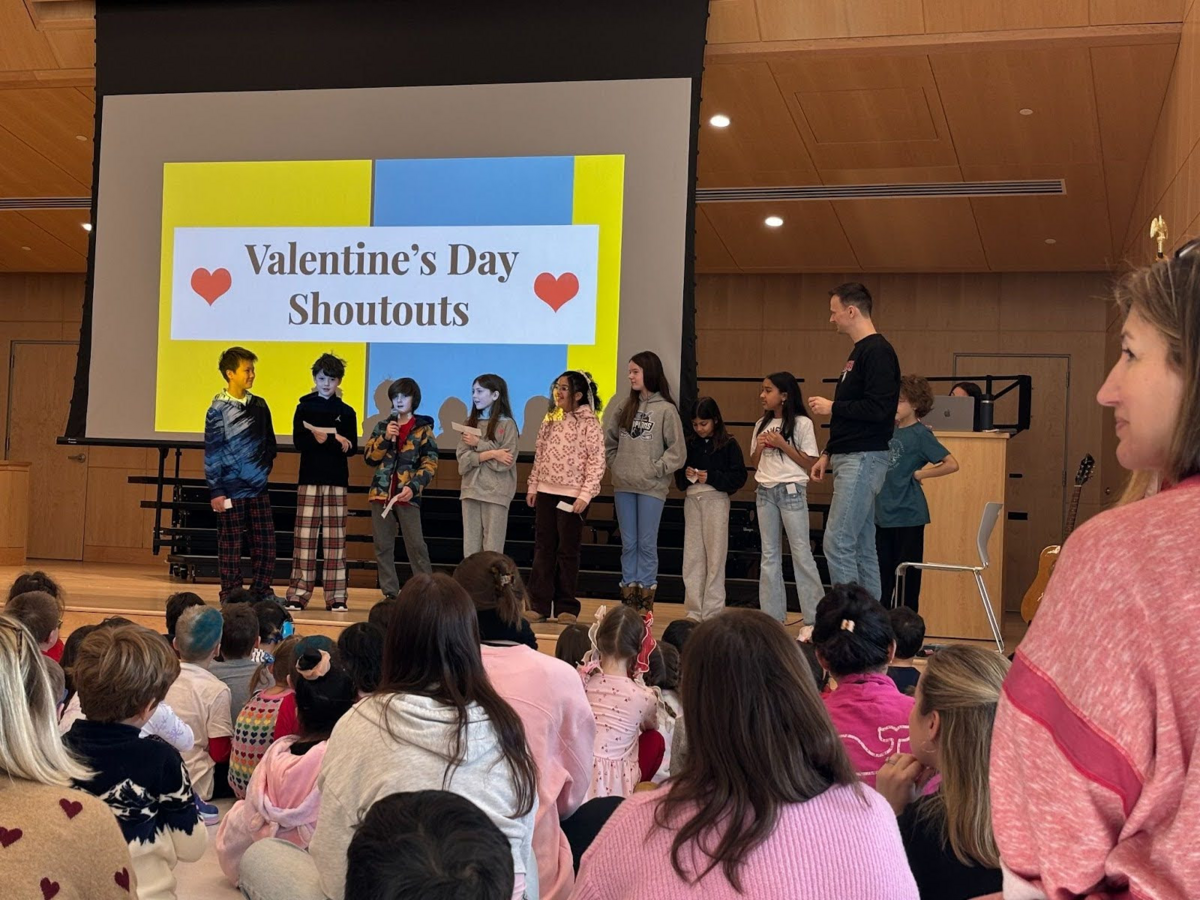 students on stage. screen behind them reads 