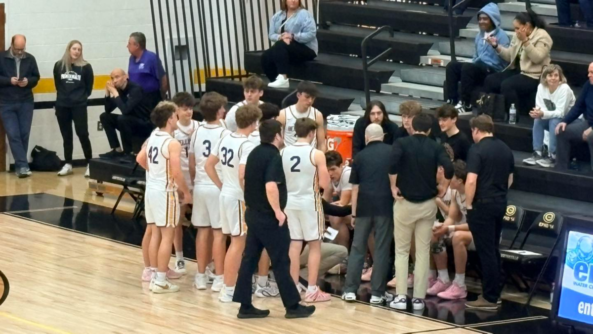Boys basketball team huddles on the sideline