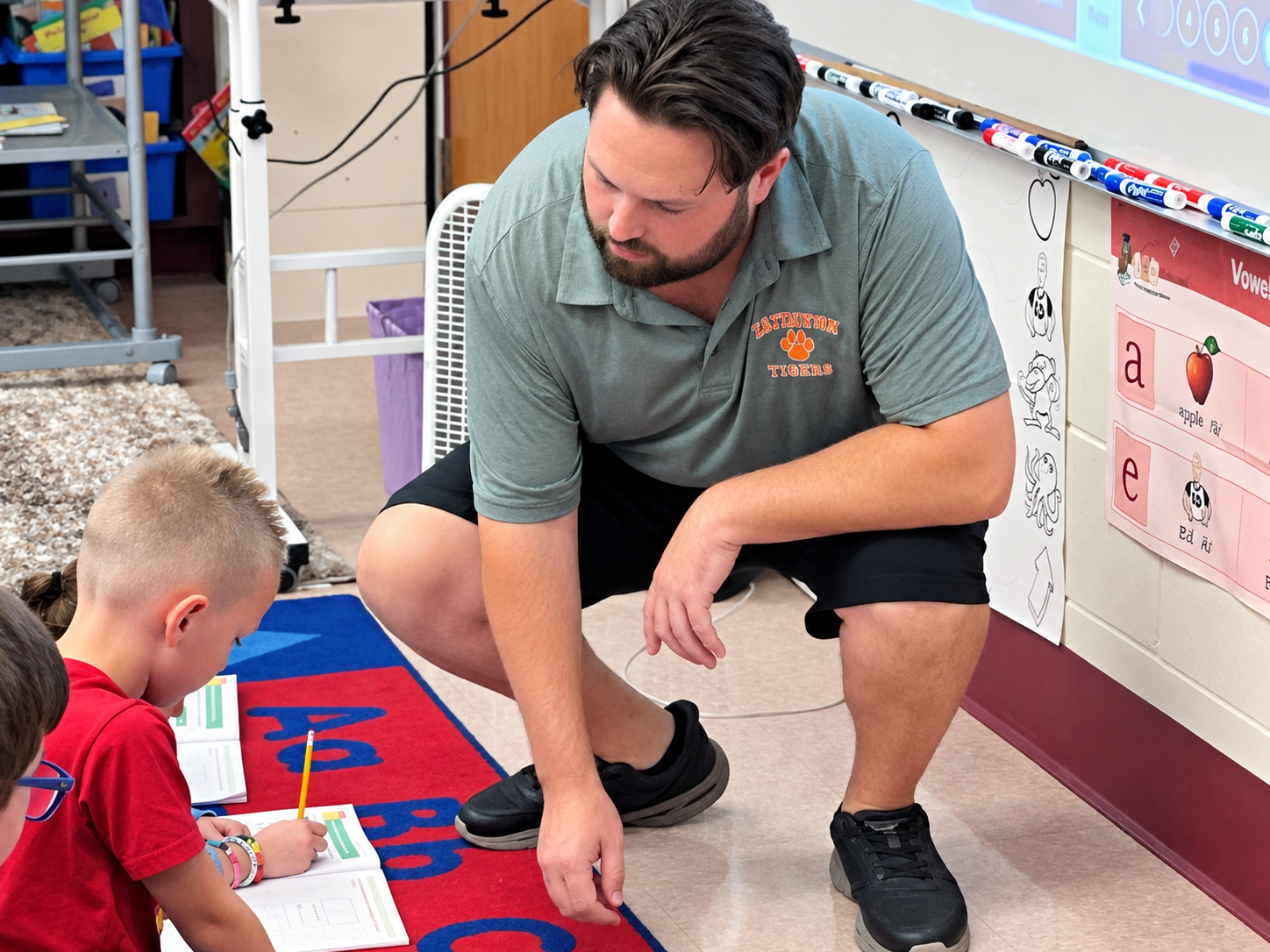 First-grade teacher Nicholas Boyle works with students at East Taunton Elementary School.