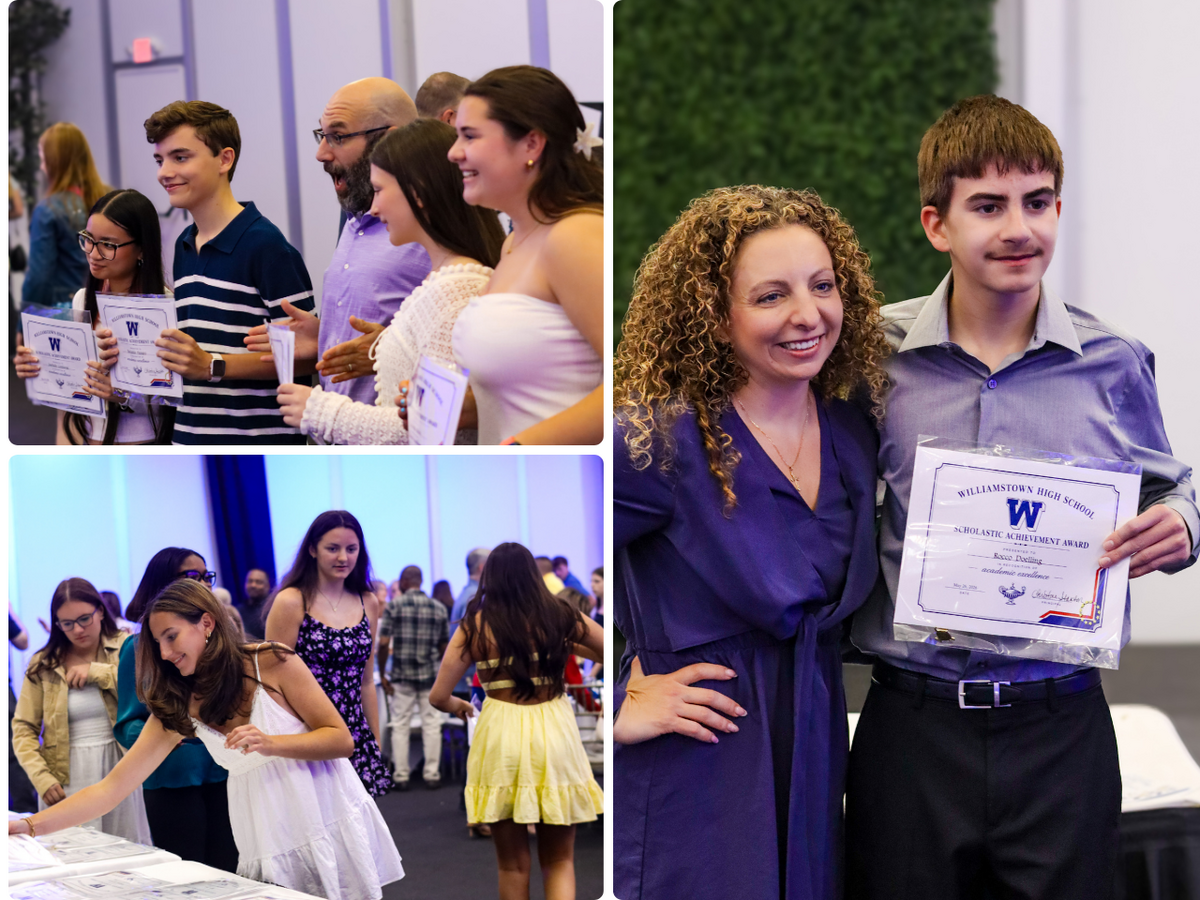 Students and adults smile while holding certificates at an awards ceremony.