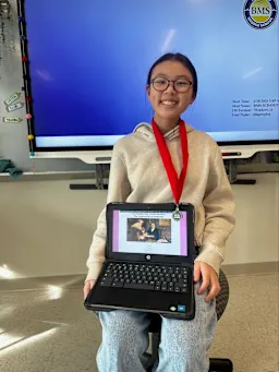 Leanne Wong holding a laptop that displays her website submission