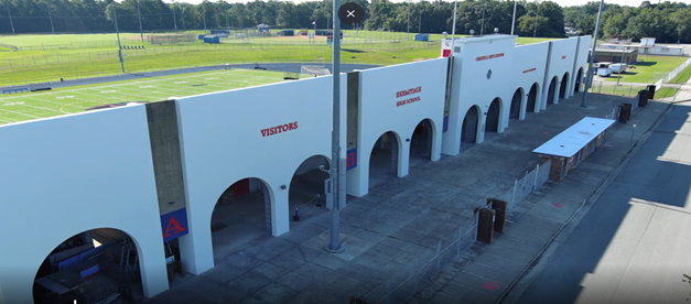 An aerial view of the Hermitage High School stadium entrance with arched walkways.