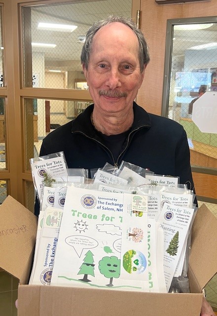 A man holds a box filled with "Trees for Tots" kits, sponsored by The Exchange of Salem, NH.