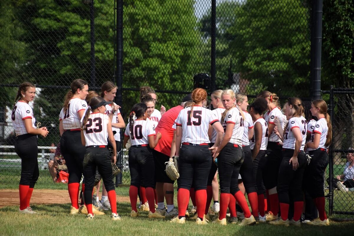 a softball team huddles pregrame on the field