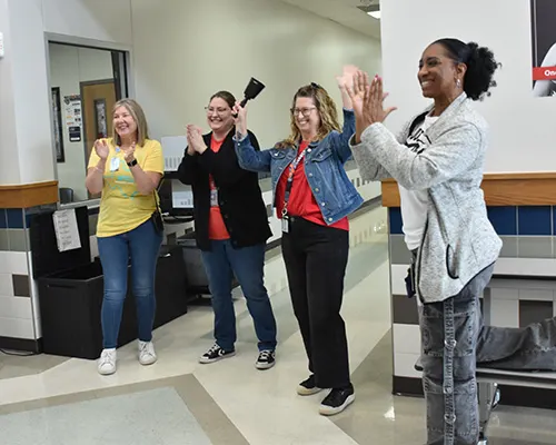 Achieve Academy staff celebrating and cheering for a recent graduate.