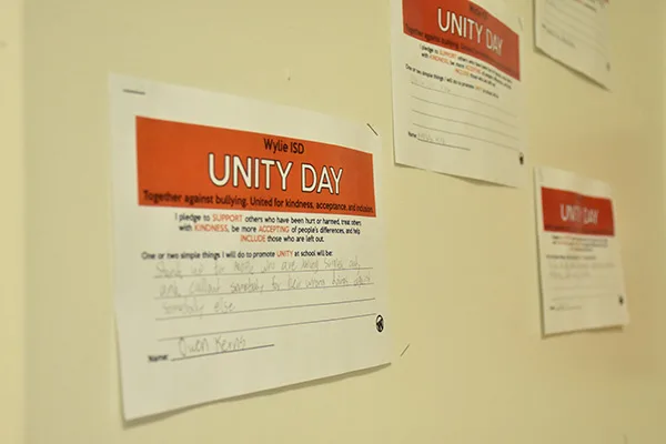 A wall at Achieve Academy decorated with Unity Day handwritten signs.
