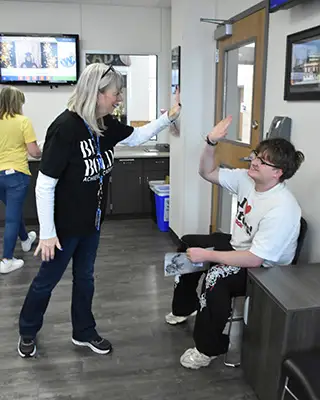 Janet Wyatt high fiving a student at Achieve Academy.