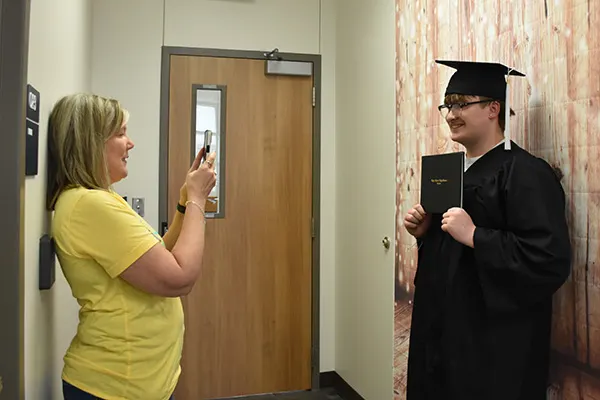Dani Womack takes a graduate's photo.