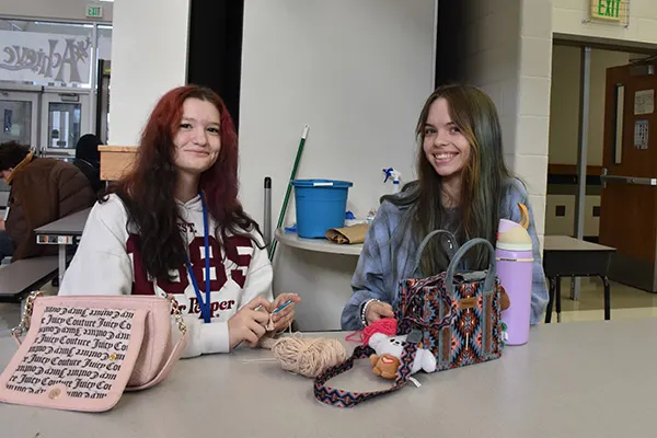 Two Achieve Academy students posing at a table.