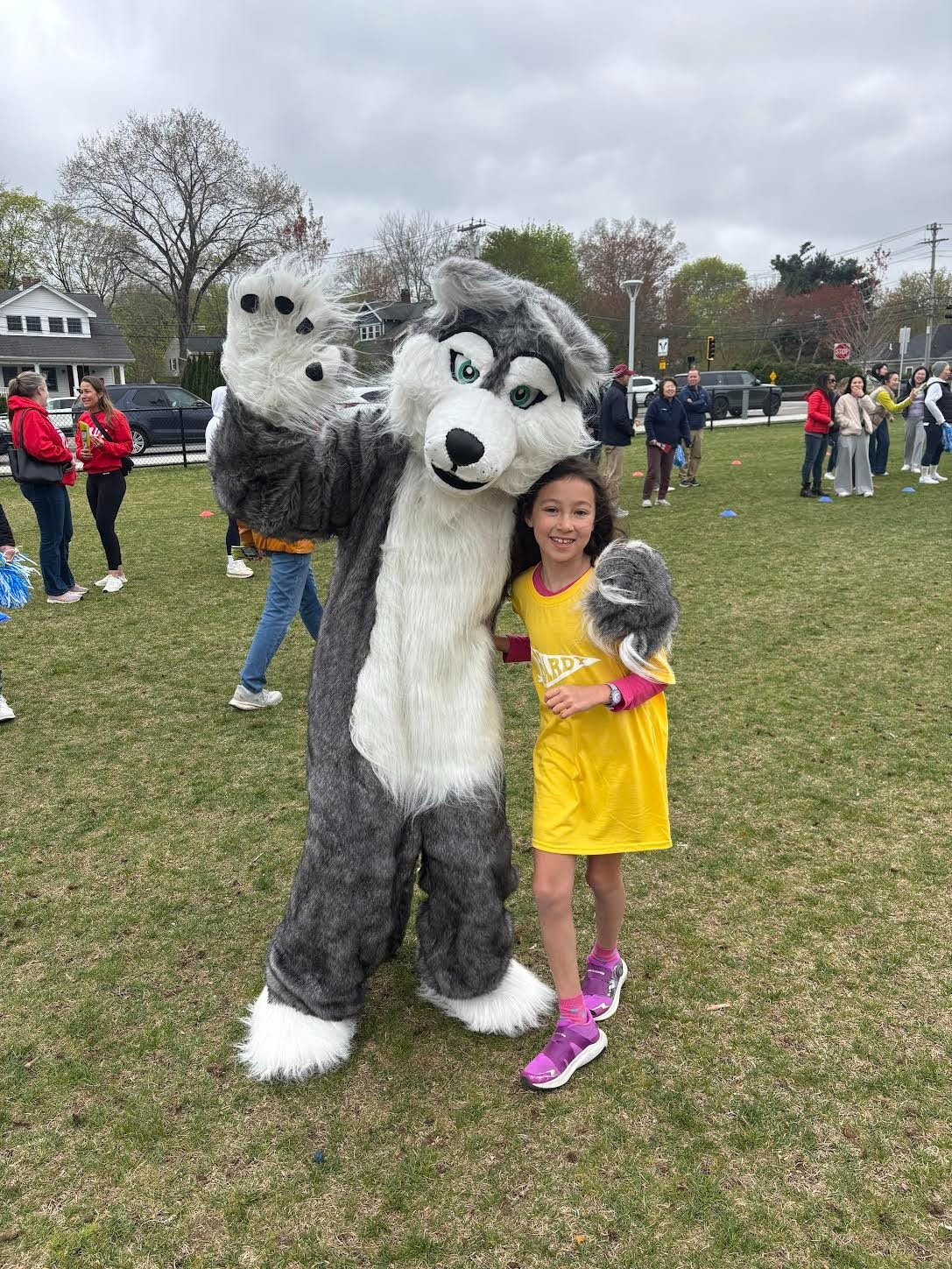 A student poses with Hero the Husky at the Hardy Fun Run.