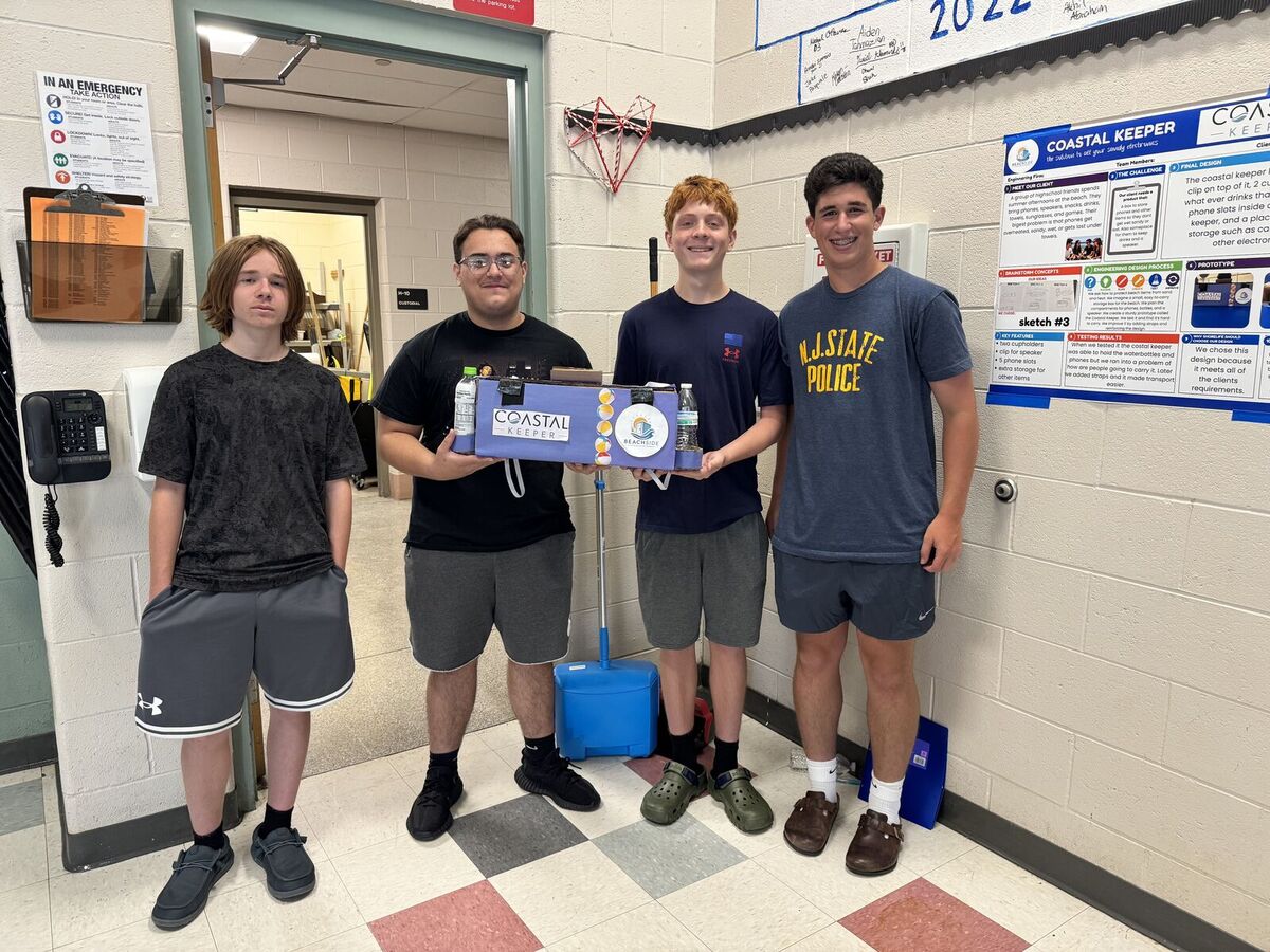 Four young people stand together, holding a blue project box labeled 'Coastal Keeper'.