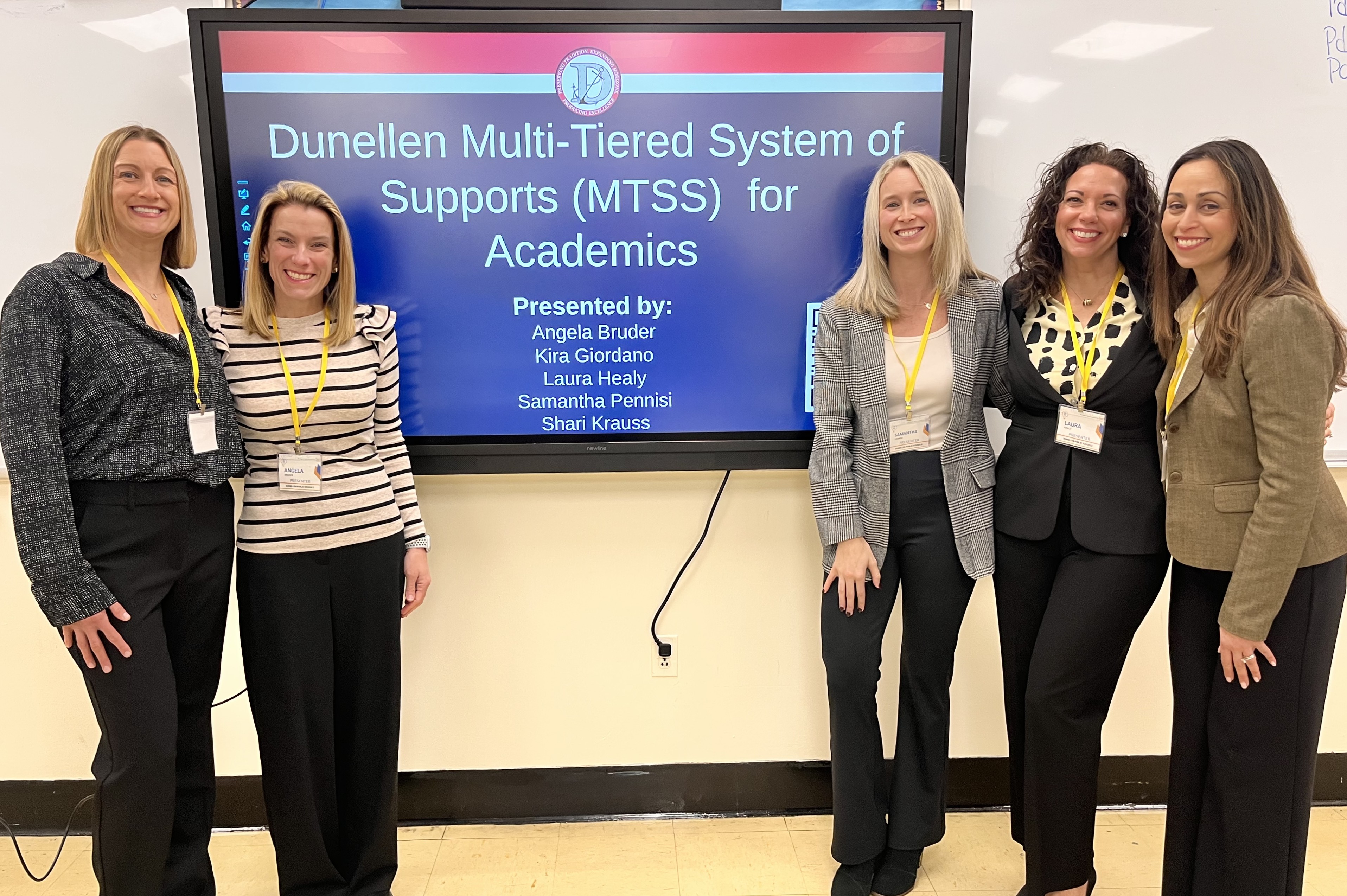 Five women stand in front of a presentation screen displaying "Dunellen Multi-Tiered System of Supports (MTSS) for Academics."