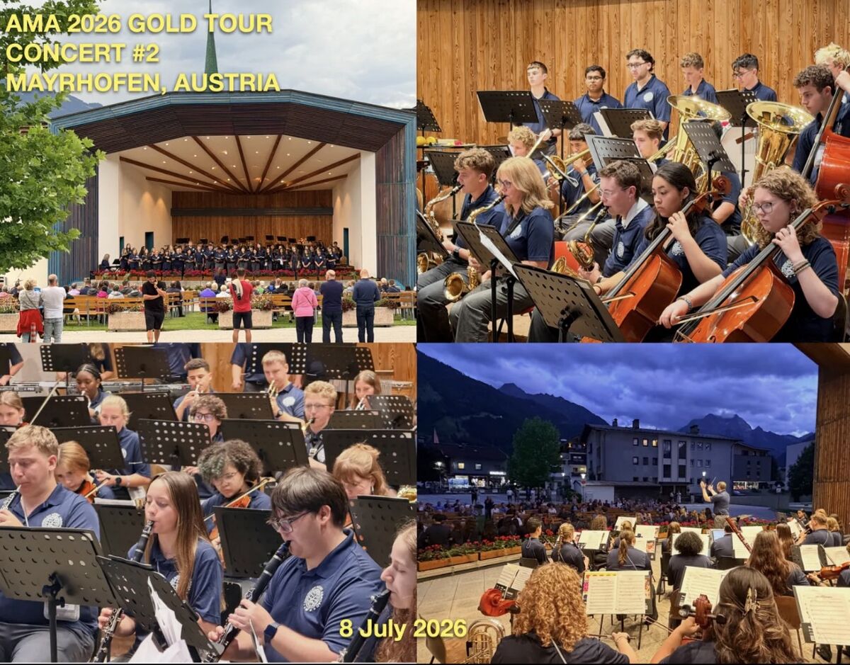 A large orchestra performs outdoors on a stage in Mayrhofen, Austria, with text indicating 'AMA 2026 GOLD TOUR CONCERT #2'.