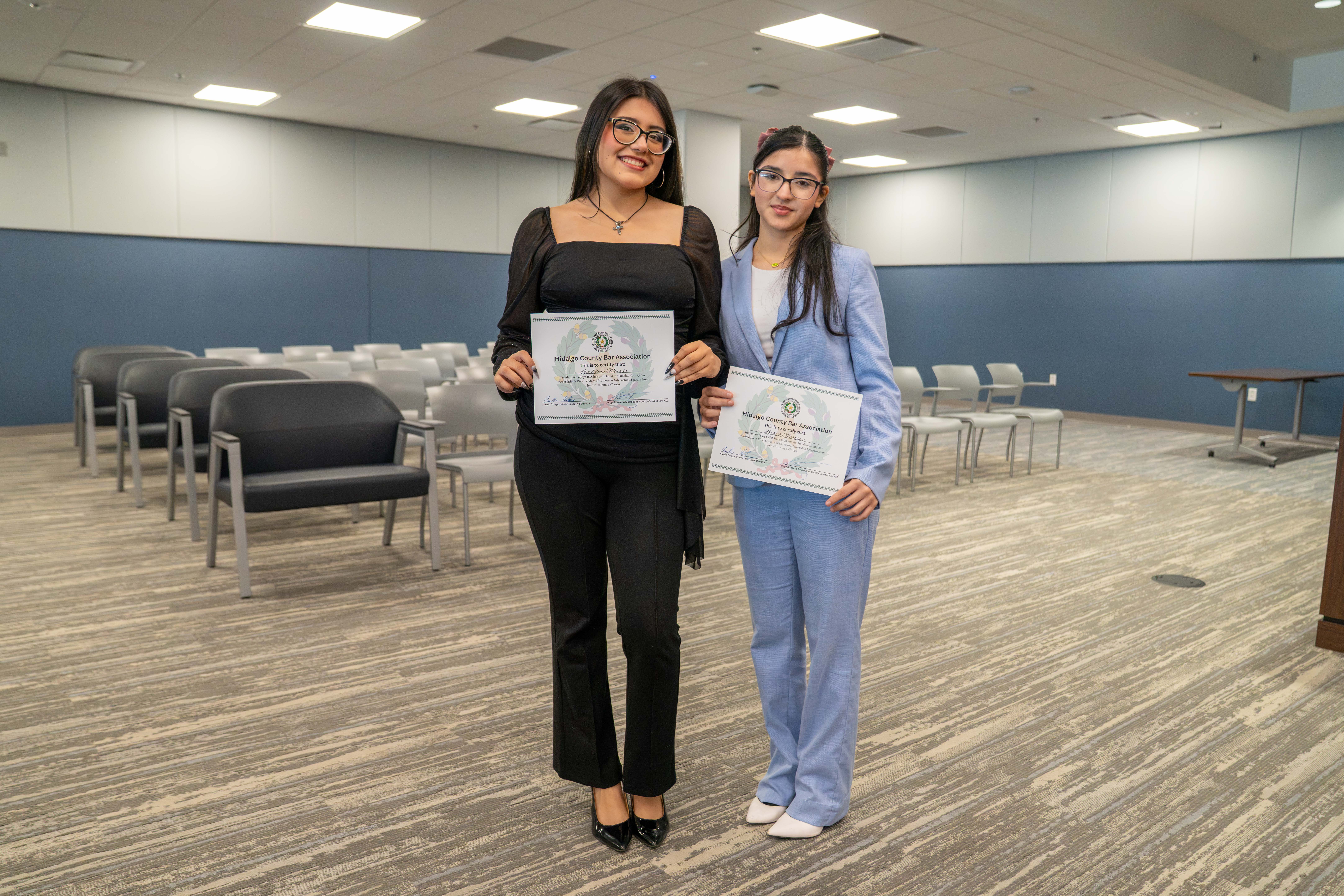 Two young women proudly hold certificates from the Hidalgo County Bar Association.