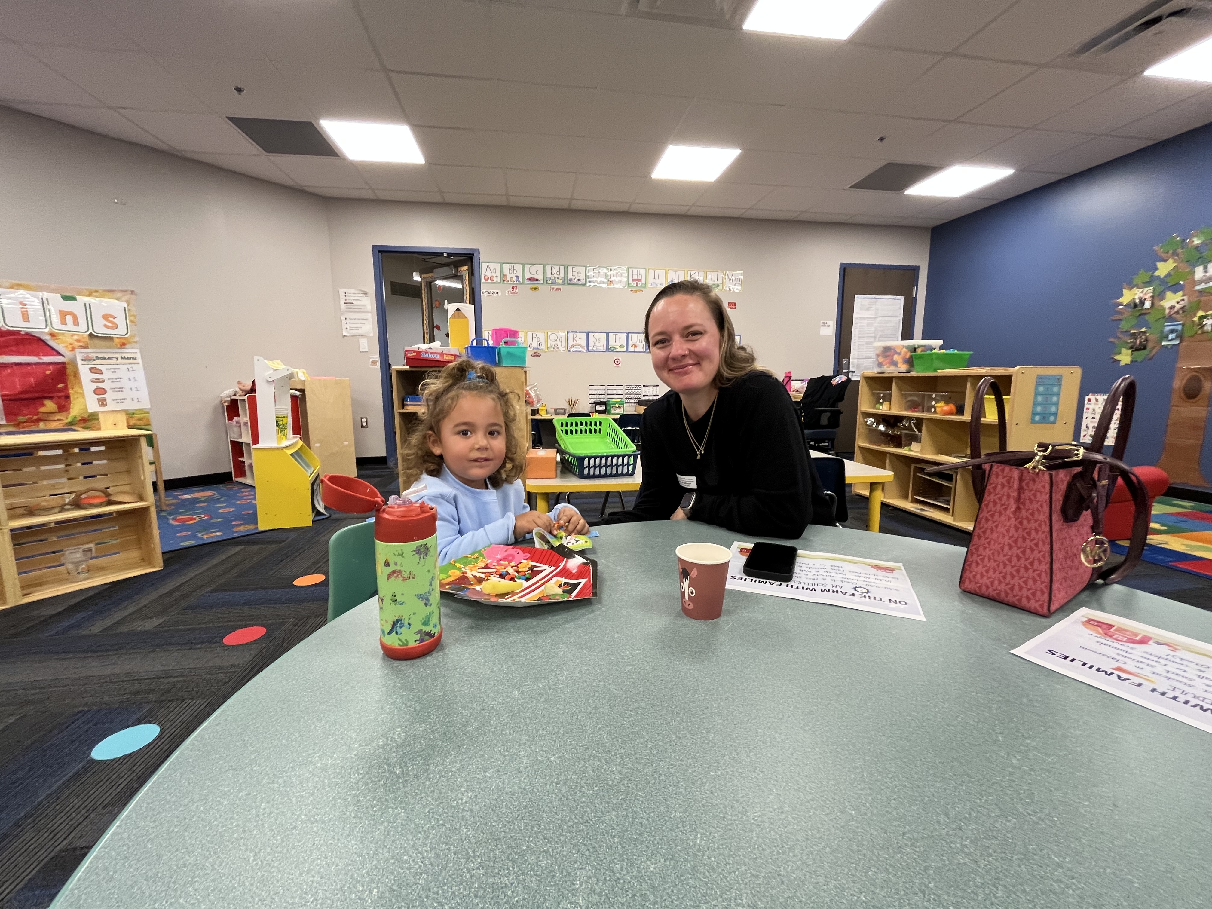 parent and student smile while enjoying a snack