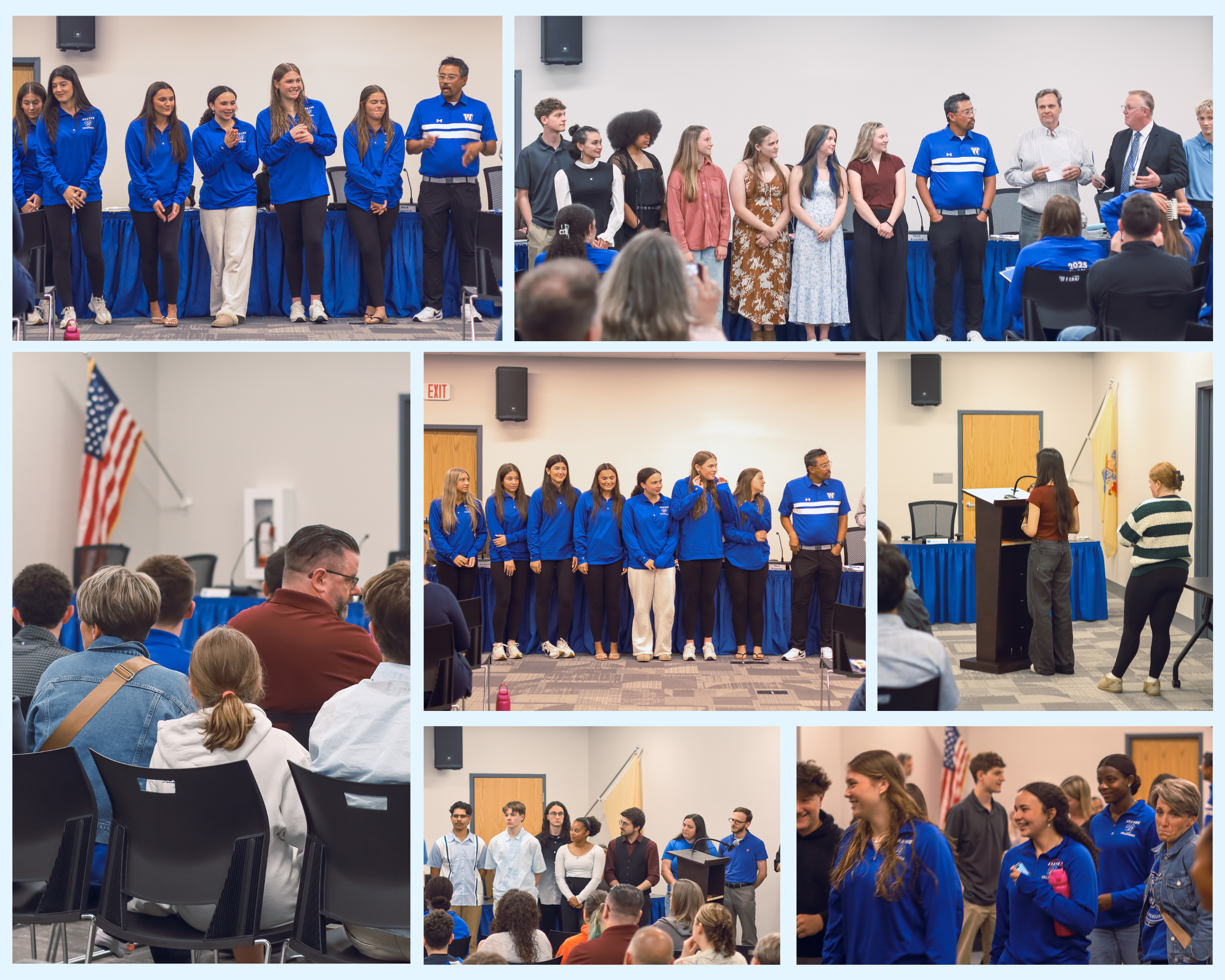 A group of young women in blue athletic shirts stand on a stage, some smiling and clapping.