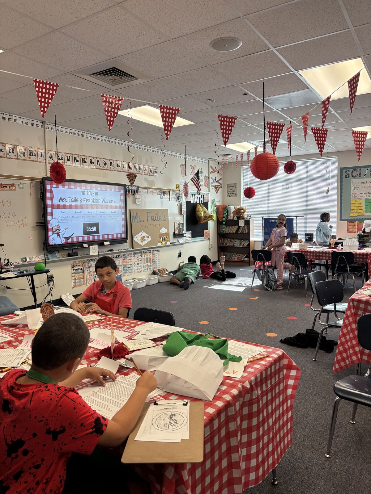 Students creating pizza themed crafts in classroom