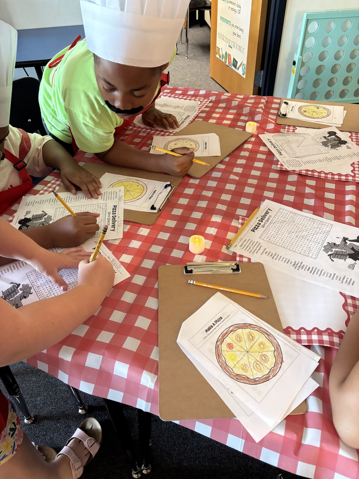 Students creating pizza themed crafts in classroom