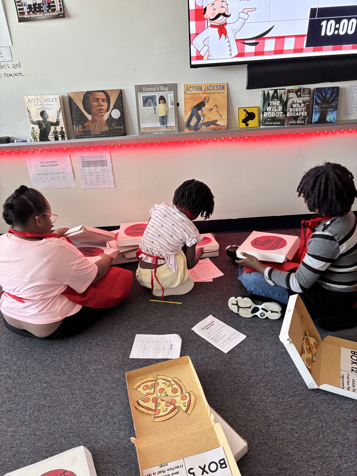 Students creating pizza themed crafts in classroom