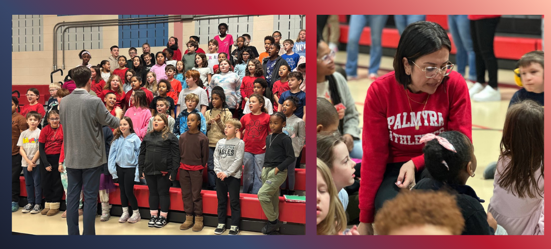 A group of children in a gymnasium stand on bleachers, facing a man in a grey sweater.