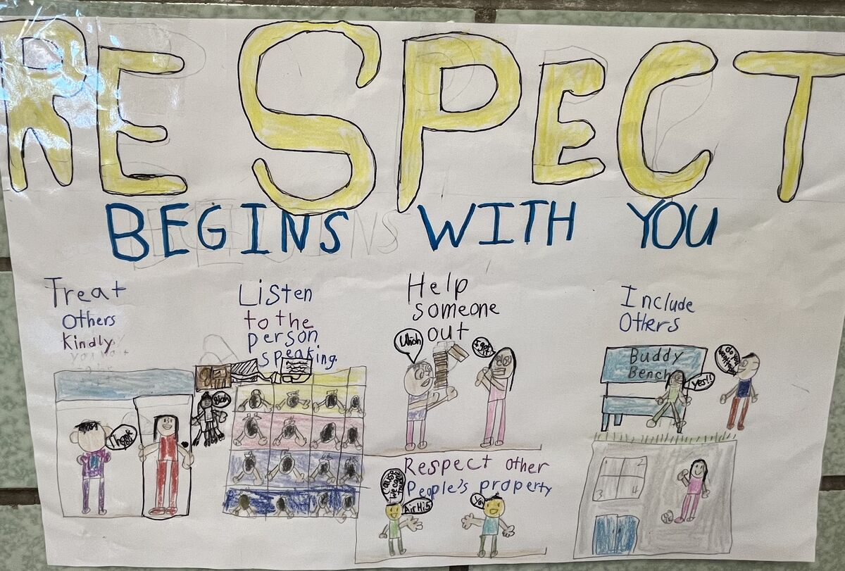 A handmade poster features the title "RESPECT BEGINS WITH YOU" in large yellow and blue letters.