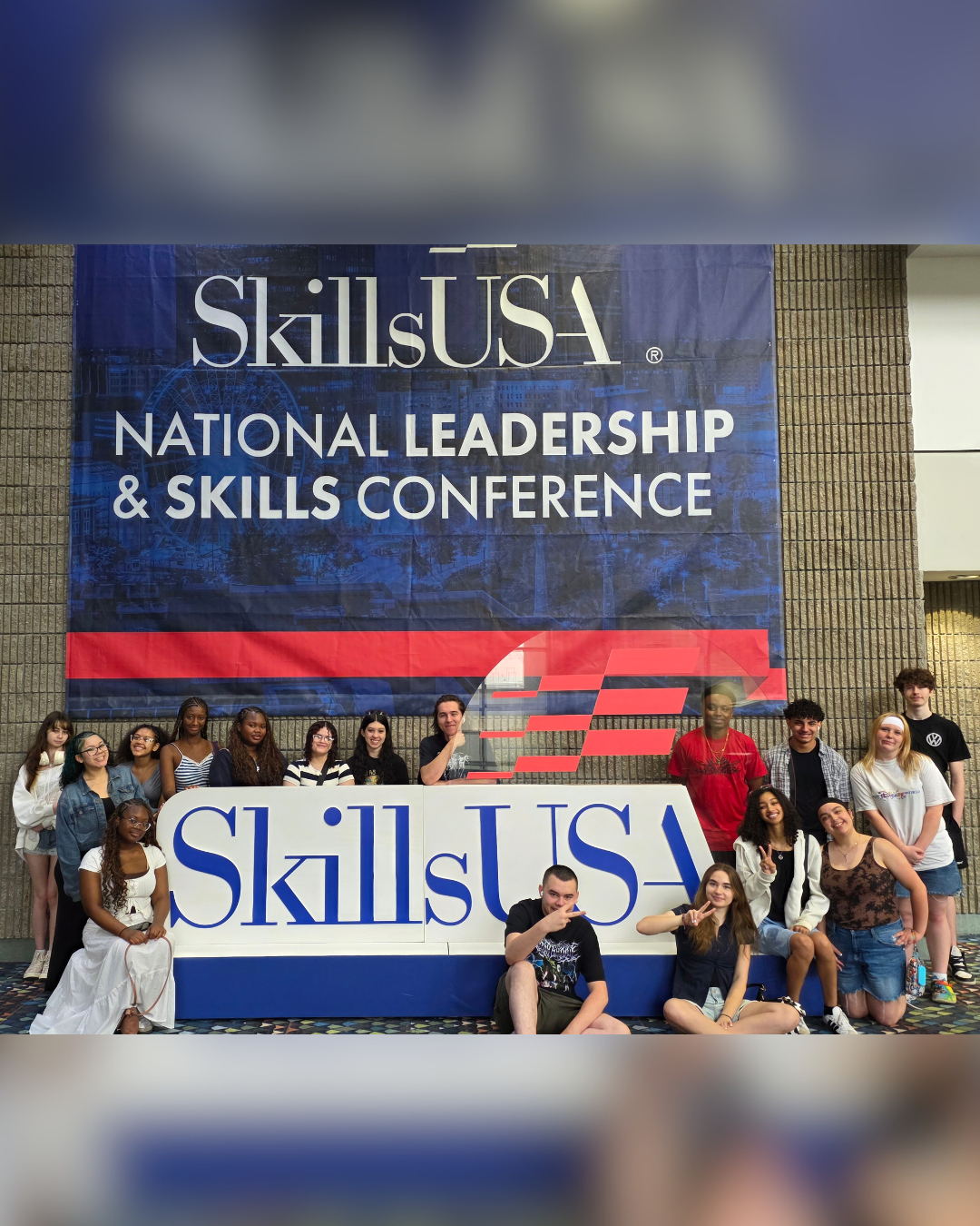 A group of young people pose for a photo in front of a SkillsUSA National Leadership & Skills Conference banner.