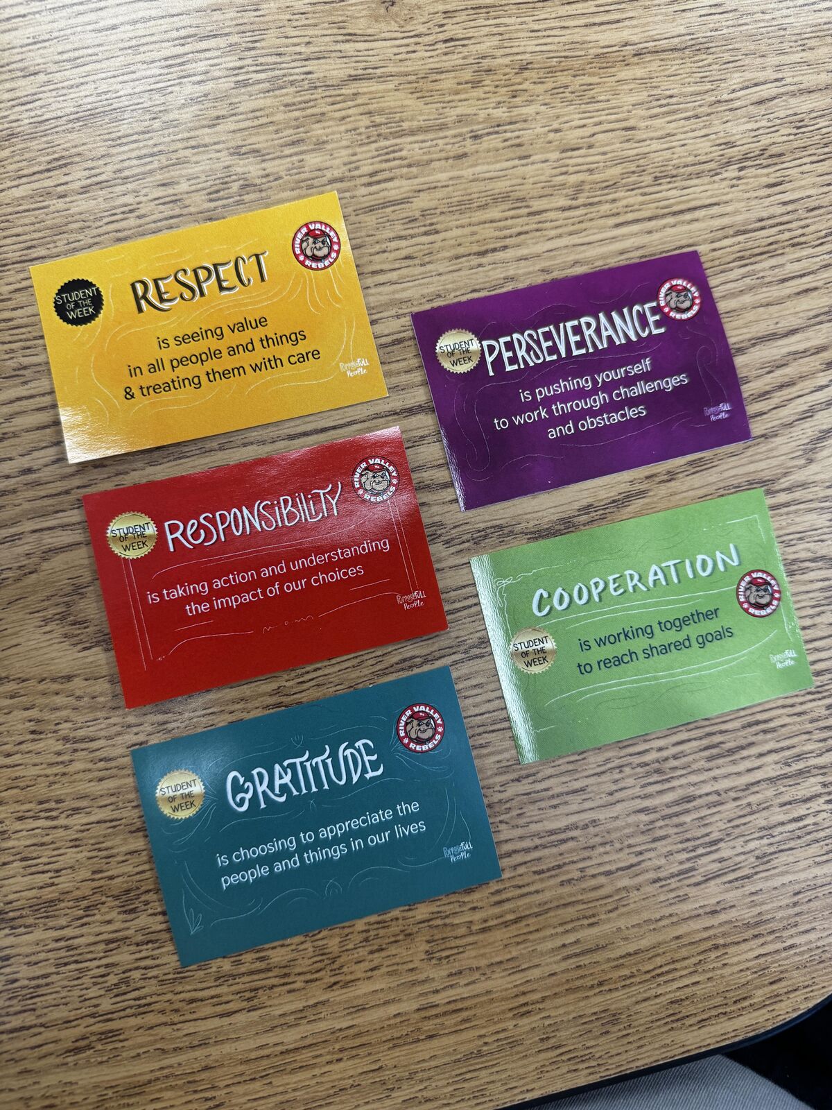 Five colorful cards display "Student of the Week" virtues: Respect, Perseverance, Responsibility, Cooperation, and Gratitude.