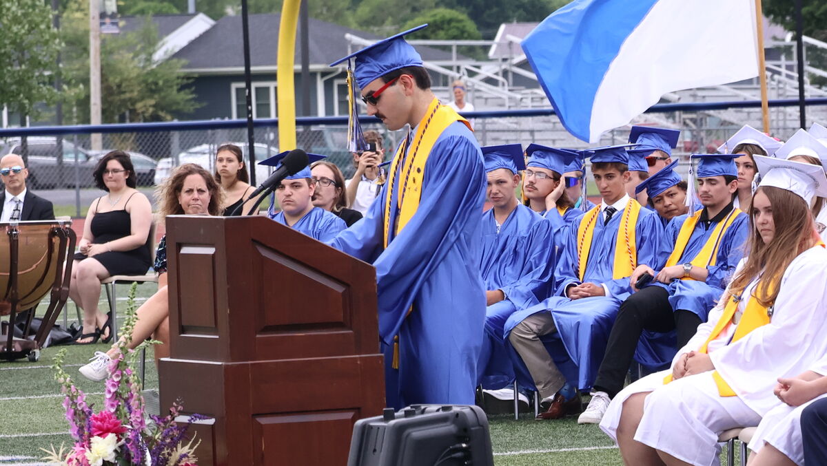 Lawrence Fiume, wearing blue cap and gown, gives the Salutatorian Address at the Lectern