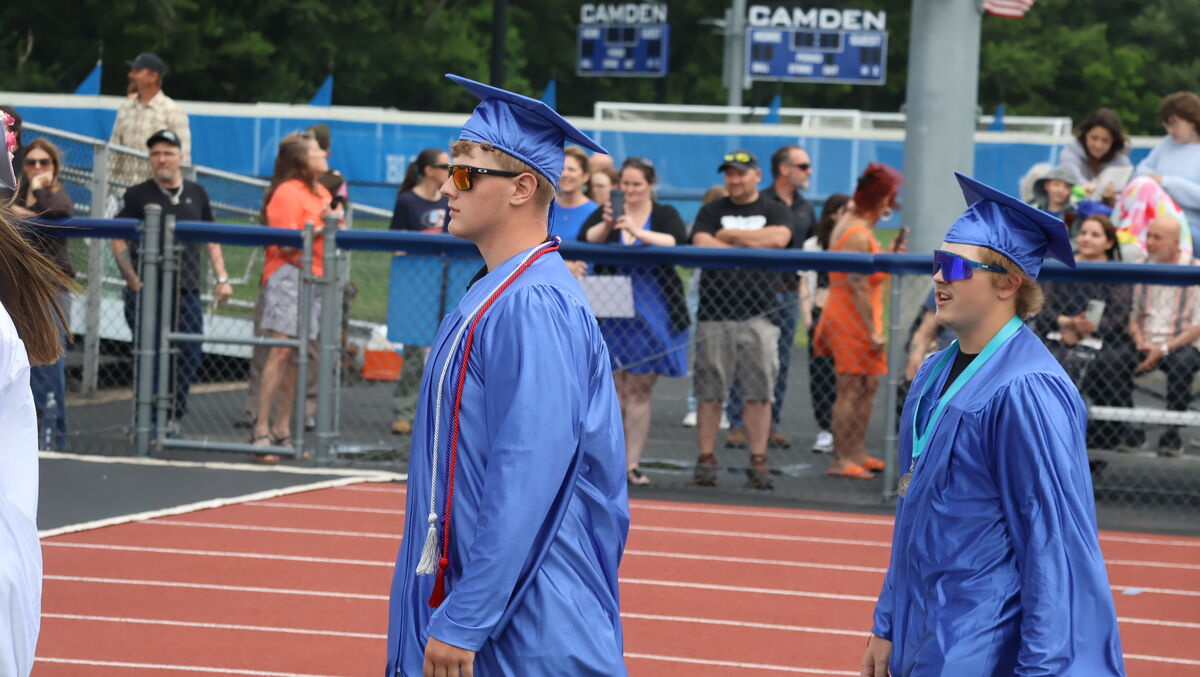 Students in blue caps and gowns participating in the processional