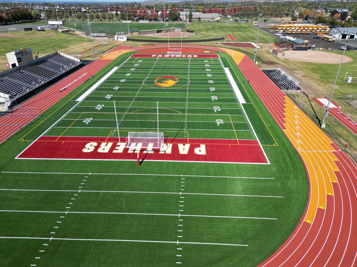 An aerial view of a football field with a track, showing yard lines and the 'PANTHERS' team name.