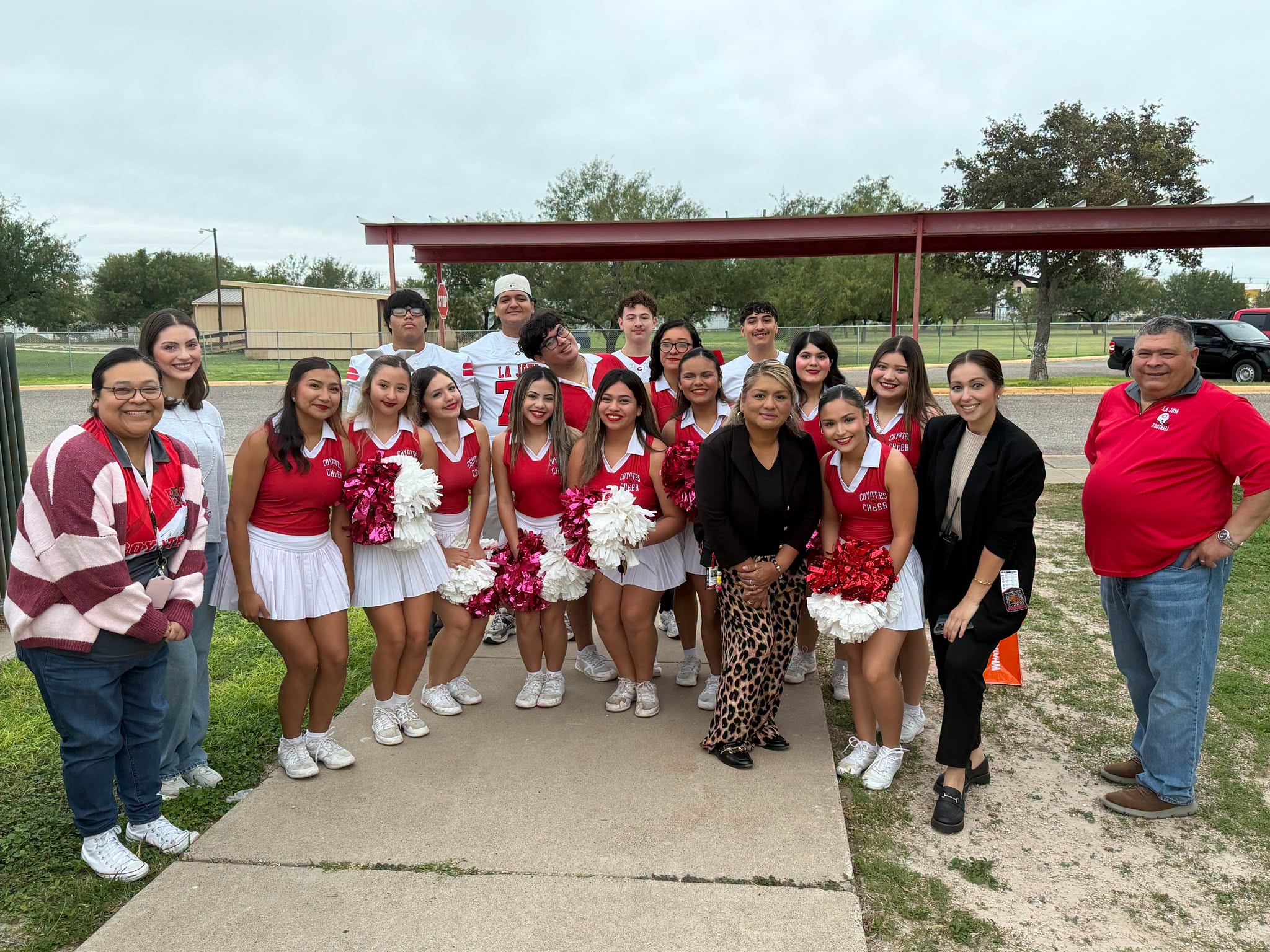 A group of high school cheerleaders pose outdoors with coaches and Tabasco admin and staff.