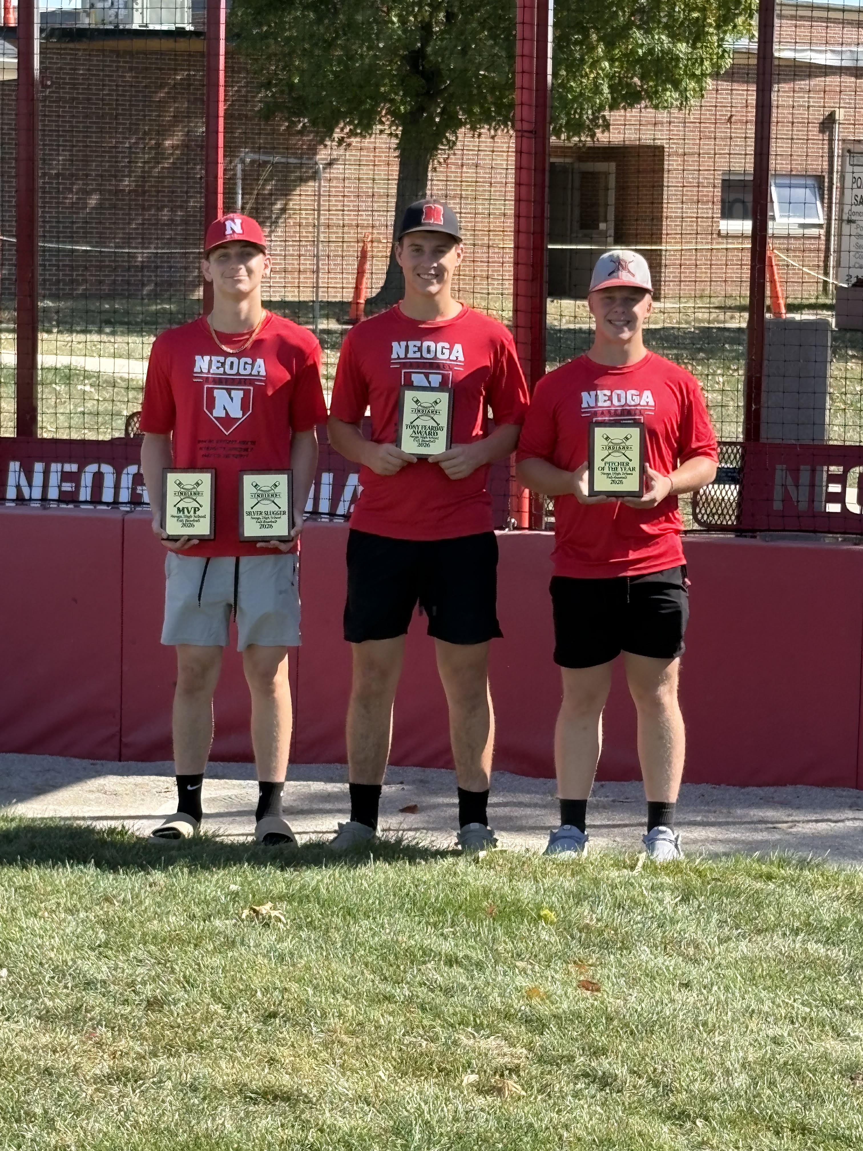 3 boys at a ball field holding awards