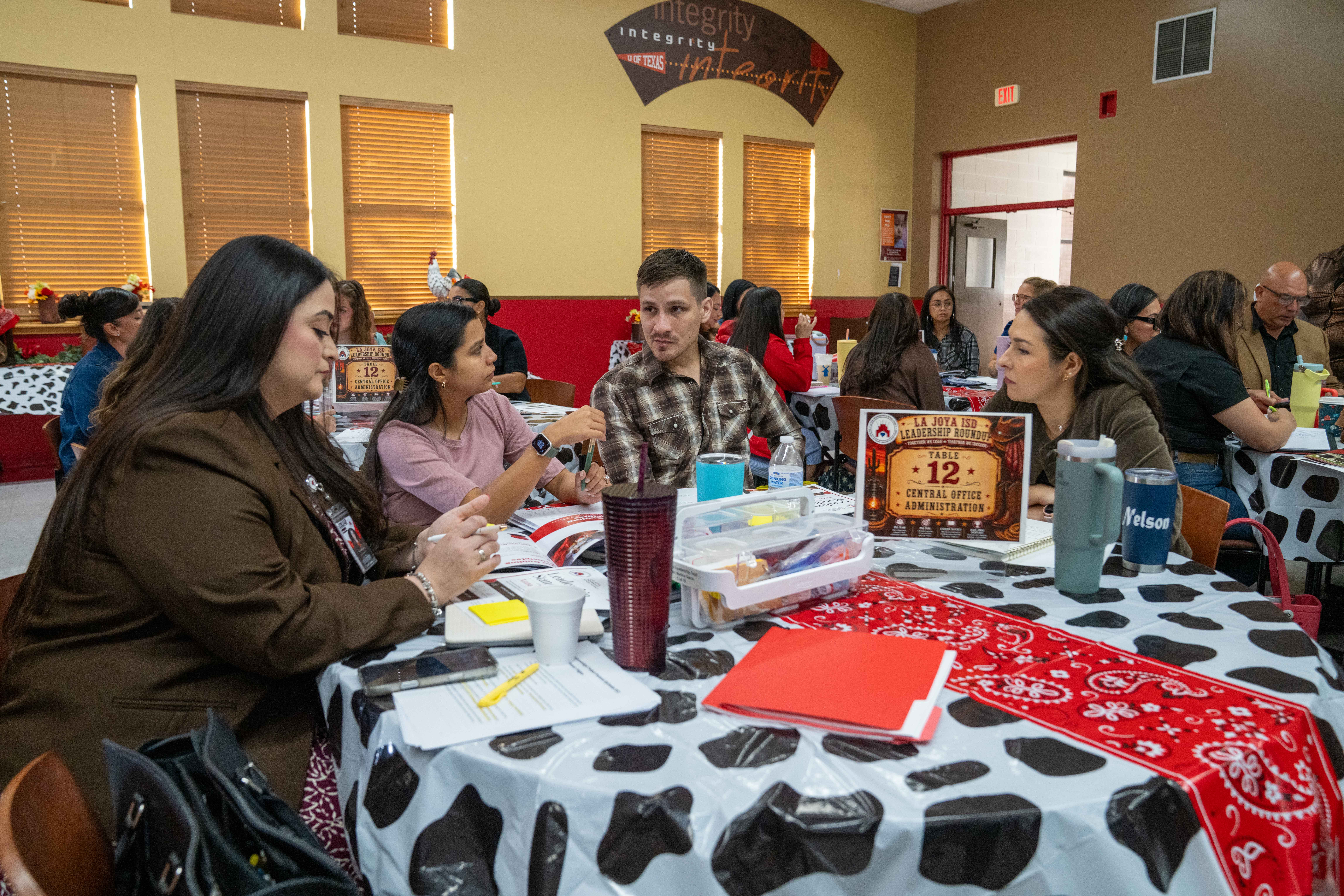 People gather around a table at a La Joya ISD Leadership Roundup event, with a sign indicating Table 12 for Central Office Administration.