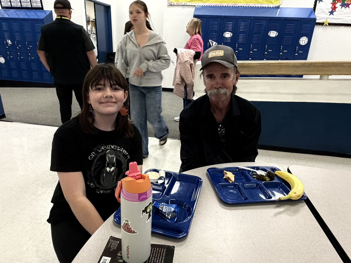 student and adult eating lunch
