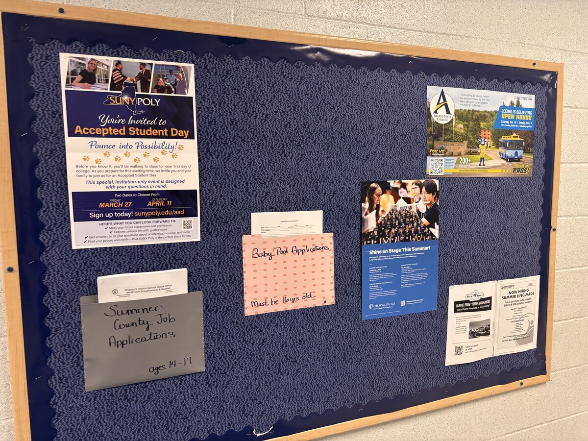 A bulletin board displays various flyers and applications, including SUNY Poly's Accepted Student Day and Summer County Job Applications.