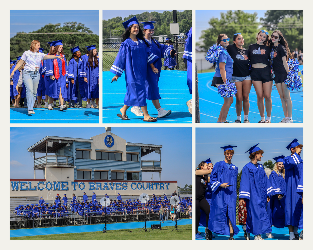 Graduates in blue gowns and caps walk on a blue track, with a stadium in the background.