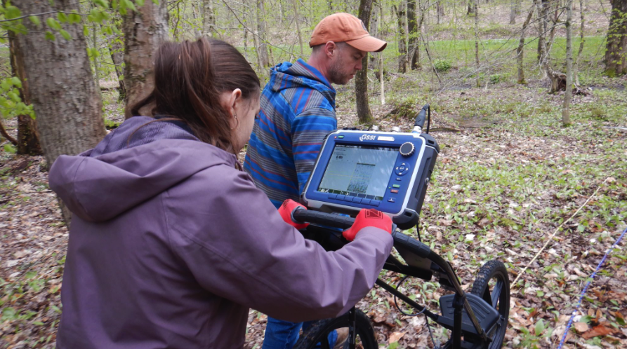 Mr. Scholz leads a student who is walking behind a ground penetrating radar machine. 