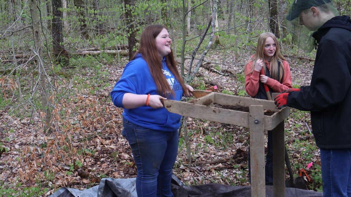 A student sifts dirt on the annual archaeological dig in Florence, NY