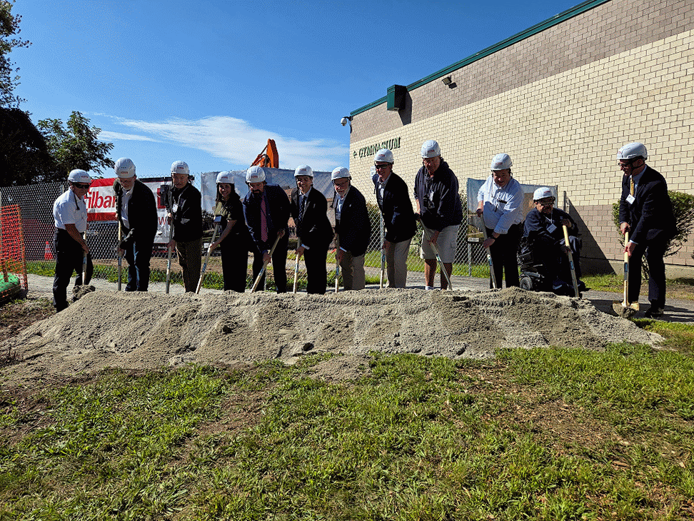 An animation of people in hardhats with gold shovels throw dirt at a Groundbreaking
