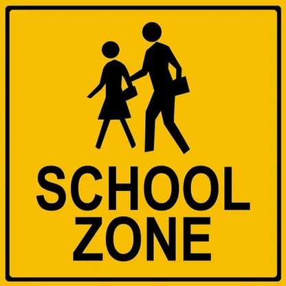 A yellow school zone sign with a pedestrian crossing symbol.