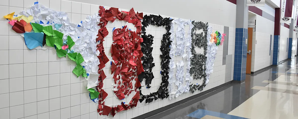 A photo of hte Cooper Junior High Origami mural that spells out C H J S.