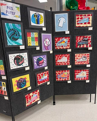 A photo of display screens containing the Veterans Day art made by Whitt students.